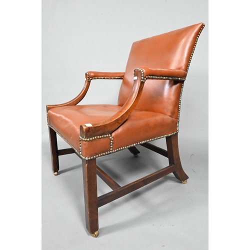 852 - An antique mahogany Gainsborough style library elbow chair, with studded brown leather upholstery, r... 