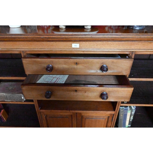 853 - A Victorian mahogany low open bookcase, centred by two long drawers over an open niche and pair cupb... 