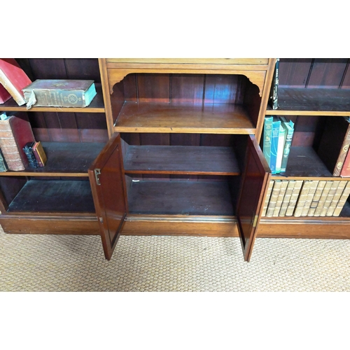 853 - A Victorian mahogany low open bookcase, centred by two long drawers over an open niche and pair cupb... 