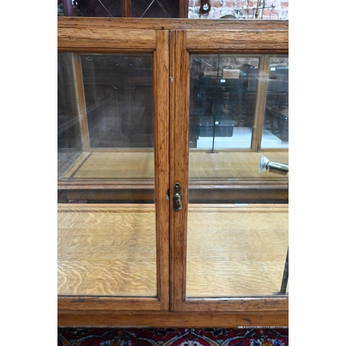 859 - A pair of 1930's oak framed glazed retailers display counters, with three doors to verso, no shelves... 