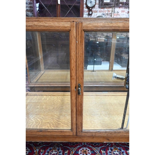 859 - A pair of 1930's oak framed glazed retailers display counters, with three doors to verso, no shelves... 