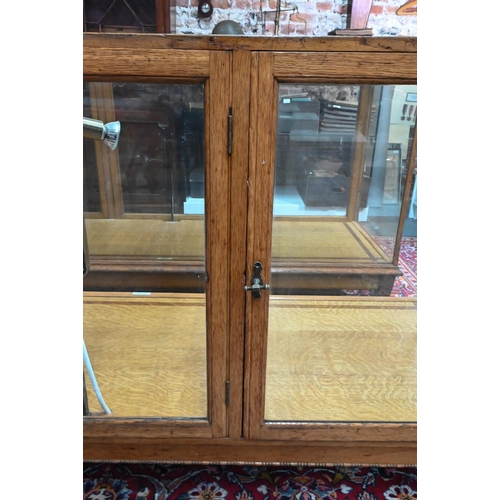 859 - A pair of 1930's oak framed glazed retailers display counters, with three doors to verso, no shelves... 