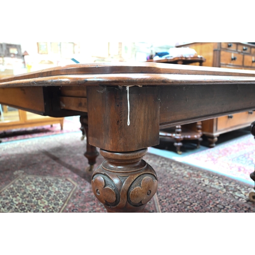 869 - A large Victorian golden oak extending table, the wind action top with rounded corners accepting the... 