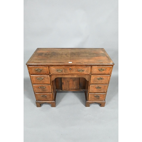 870 - A Georgian style feather-banded walnut kneehole desk, with an arrangement of nine drawers around a r... 