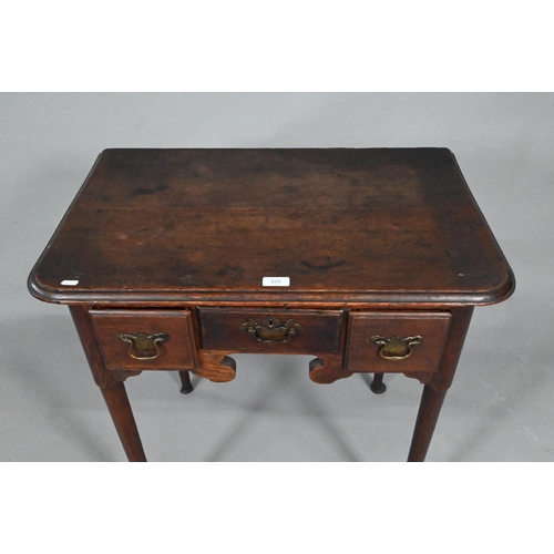 878 - An 18th century oak three drawer low boy side table, raised on slender turned tapering legs to pad f... 