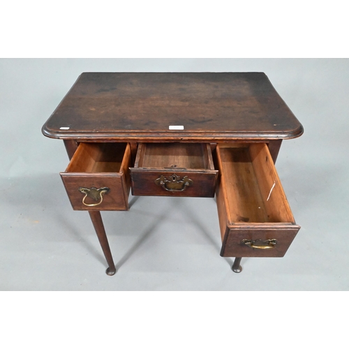 878 - An 18th century oak three drawer low boy side table, raised on slender turned tapering legs to pad f... 