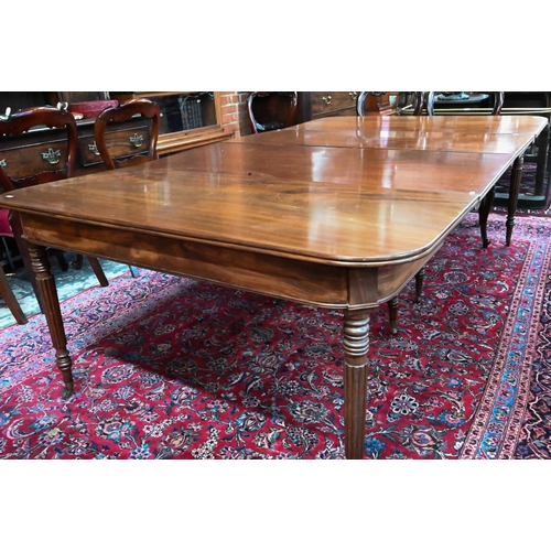 879 - A George III mahogany dining table, the pair of d-ends with twin gate-legs united by two extension l... 