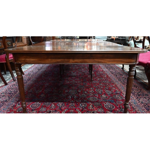 879 - A George III mahogany dining table, the pair of d-ends with twin gate-legs united by two extension l... 