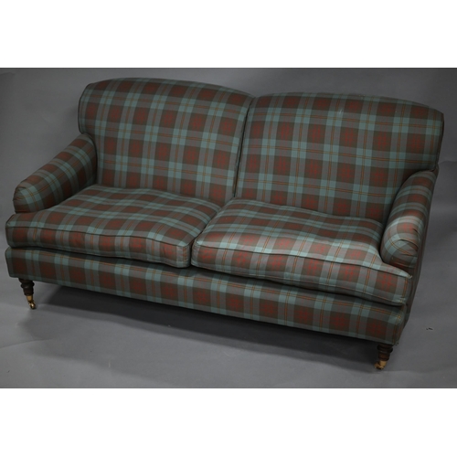 880 - A contemporary pale green / red chesk patterned two seat sofa, on turned mahogany legs to brass cast... 