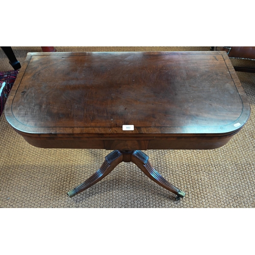 883 - A Victorian ebony-strung mahogany card table, the fold-over top revealing a storage well, raised on ... 