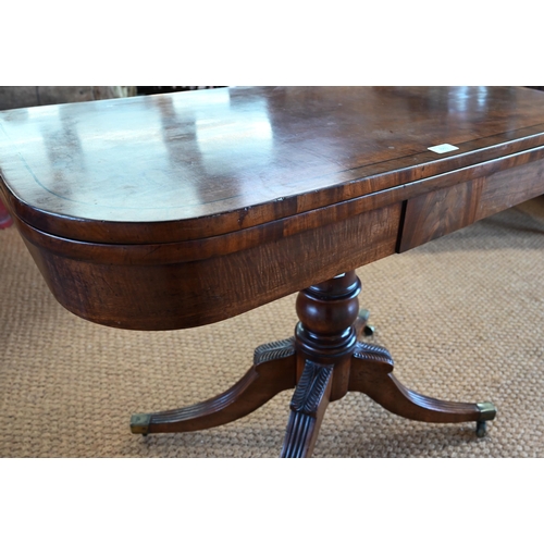 883 - A Victorian ebony-strung mahogany card table, the fold-over top revealing a storage well, raised on ... 