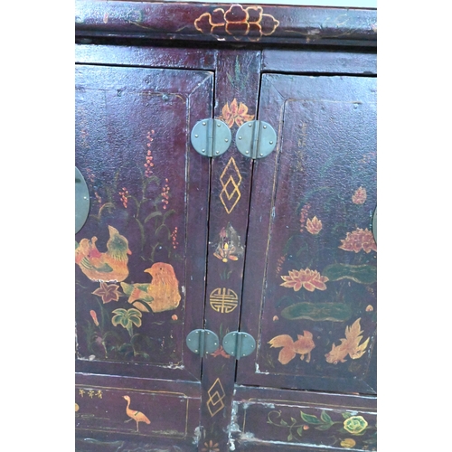 891 - An antique Chinese red laquer and polychrome decorated two door cabinet, presented in distressed con... 