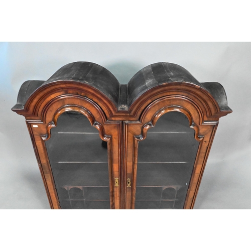 892 - A William & Mary period walnut double dome top cabinet, with pair of arched glazed doors enclosi... 