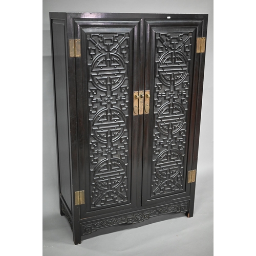 896 - An early 20th century Chinese ebonised carved hardwood wood cabinet, the twin doors with shou symbol... 