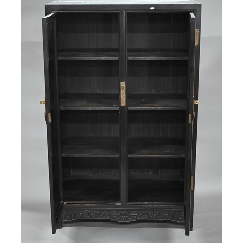 896 - An early 20th century Chinese ebonised carved hardwood wood cabinet, the twin doors with shou symbol... 