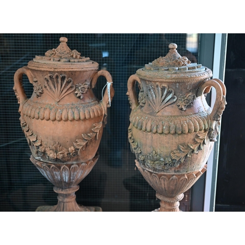 901 - A large pair of weathered classical cast terracotta lidded urns, with twin loop handles and decorate... 