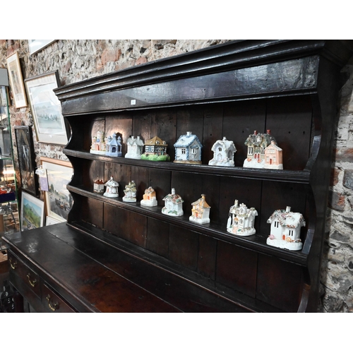 904 - A Georgian oak three drawer dresser, with associated rack (reduced in height), with planked pot boar... 