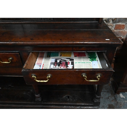 904 - A Georgian oak three drawer dresser, with associated rack (reduced in height), with planked pot boar... 