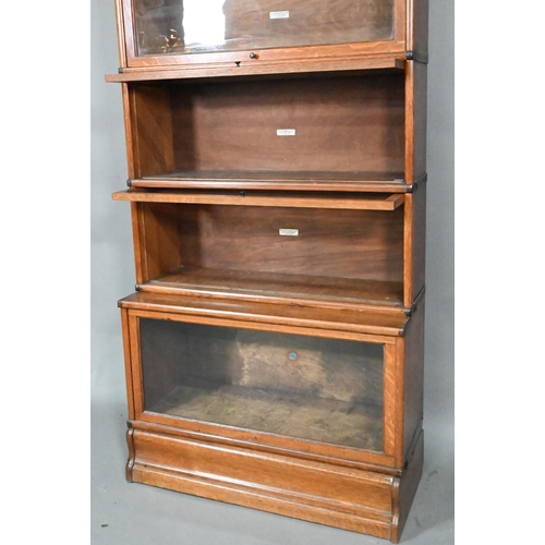 905 - A golden oak Globe Wernicke library bookcase, the four glazed sections over a single deep glazed bas... 