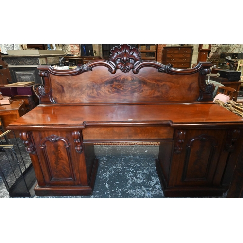 907 - A large Victorian mahogany country house twin pedestal sideboard, the heavily moulded back over a ce... 