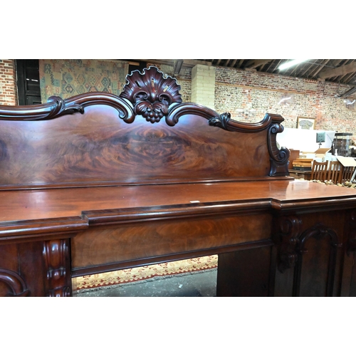 907 - A large Victorian mahogany country house twin pedestal sideboard, the heavily moulded back over a ce... 