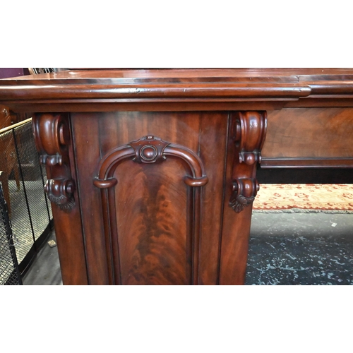 907 - A large Victorian mahogany country house twin pedestal sideboard, the heavily moulded back over a ce... 