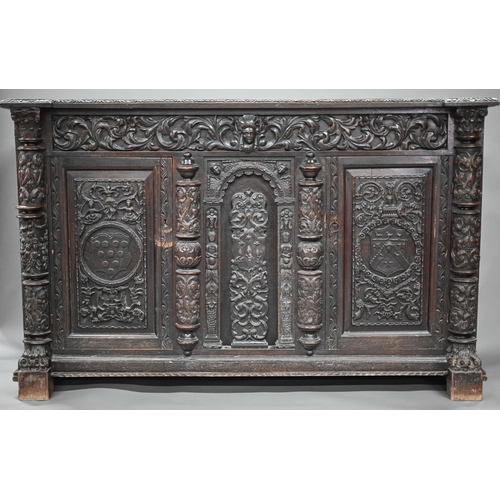 910 - A large antique jointed, carved and applied carved moulded oak library cabinet in the Flemish style,... 