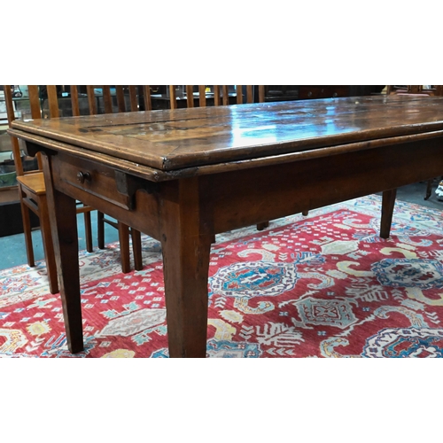 913 - An antique French fruitwood extending draw leaf dining table, with frieze drawer to one end, raised ... 