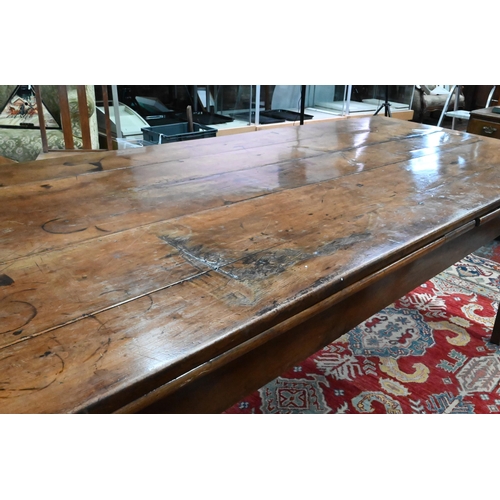 913 - An antique French fruitwood extending draw leaf dining table, with frieze drawer to one end, raised ... 