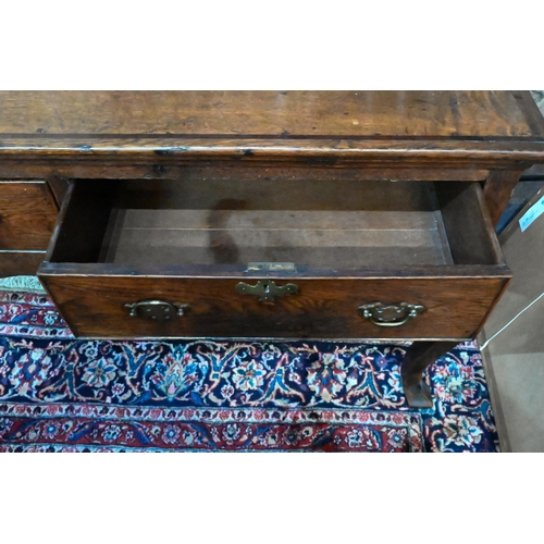 914 - An 18th century cross-banded oak low dresser, with three cock-beaded frieze drawers over a wavy apro... 