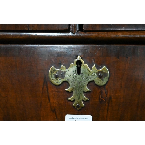 915 - An 18th century and later oak and walnut chest on stand, two short over three long graduated drawers... 