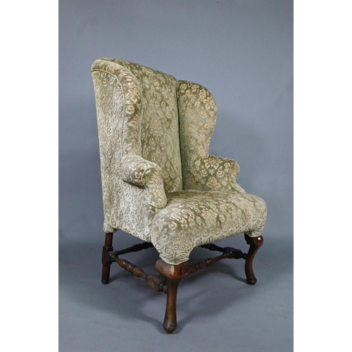 917 - An oak framed upholstered Wing armchair, 19th century, raised on cabriole front legs united by stret... 