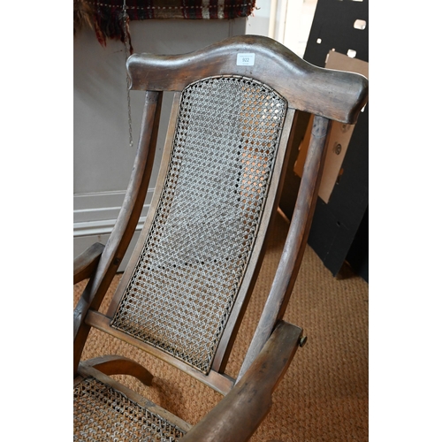 922 - An Edwardian beech framed folding steamer chair, with caned panels and foot extension