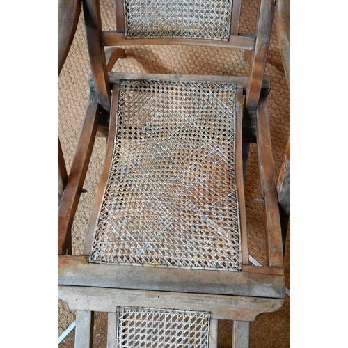 922 - An Edwardian beech framed folding steamer chair, with caned panels and foot extension