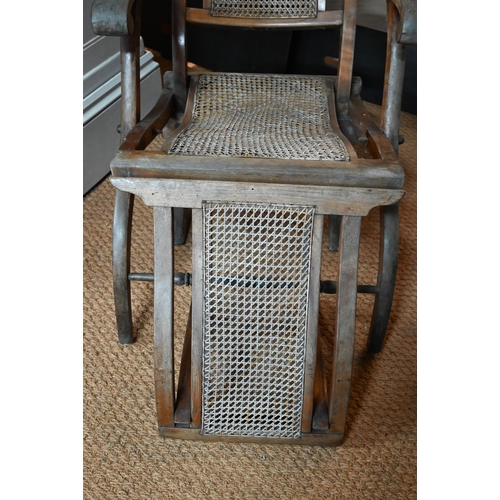 922 - An Edwardian beech framed folding steamer chair, with caned panels and foot extension