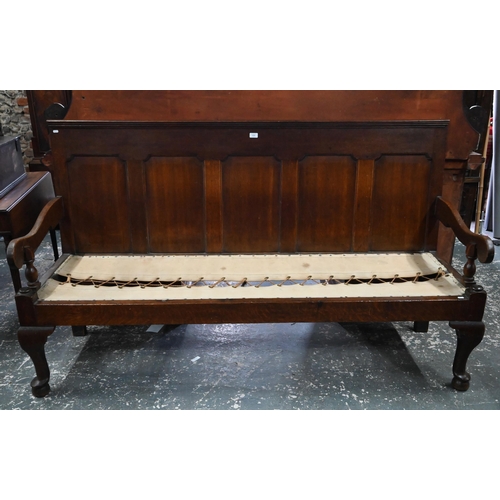 926 - An 18th century oak panel backed settle, with shaped arms over a rope and canvas seat (cushion inclu... 