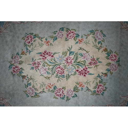 835 - A mid-century Kashmir crewel work rug, floral design on pale green ground, 178 cm x 115 cm