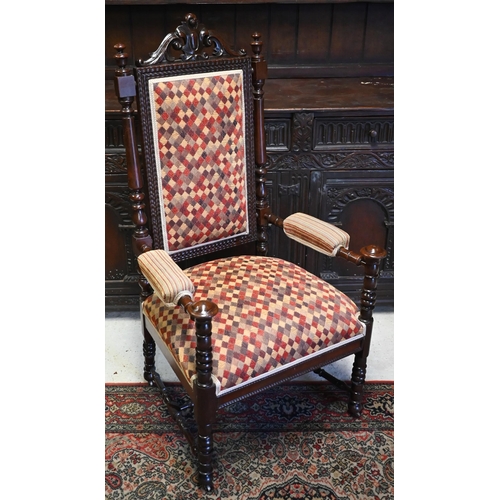 580 - An antique oak open armchair, overstuffed with diamond pattern upholstery