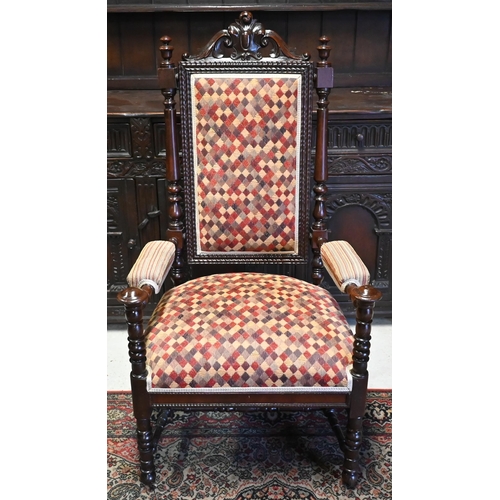 580 - An antique oak open armchair, overstuffed with diamond pattern upholstery