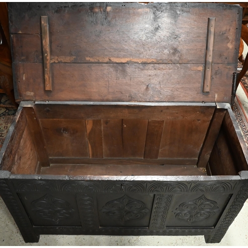 602 - An antique oak coffer with lunette and foliate carved panelled front, 130 cm wide x 58 cm deep x 76 ... 