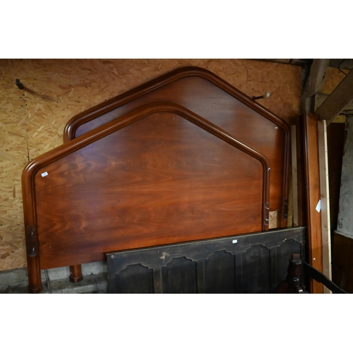 606 - A Kingsize stained hardwood bedframe with shaped mouldings and arched ends, 200 cm wide