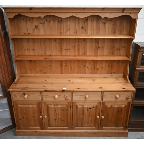 374 - A large modern pine dresser, the shaped plate rack with slatted back and two shelves on a base with ... 