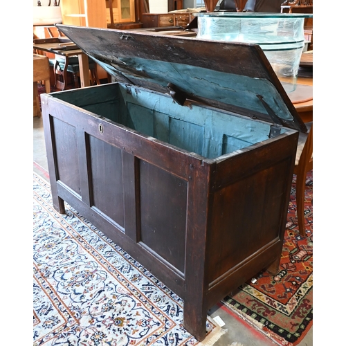 380 - A large antique panelled oak coffer, hinged top enclosing the deep storage area, 138 cm wide x 56 cm... 