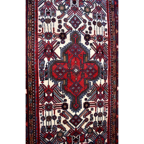 48 - A contemporary rug/runner, the geometric design on red and cream ground, 198 cm x 94 cm