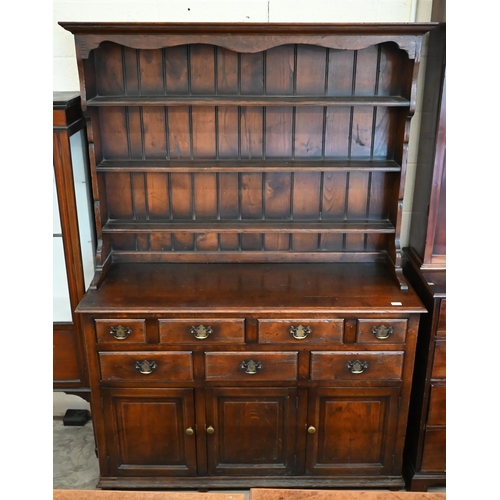 385 - An 18th century style provincial oak dresser, the raised plate rack with three open shelves on a bas... 