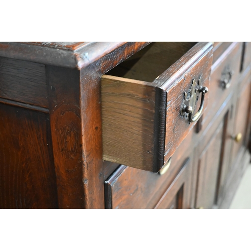 385 - An 18th century style provincial oak dresser, the raised plate rack with three open shelves on a bas... 