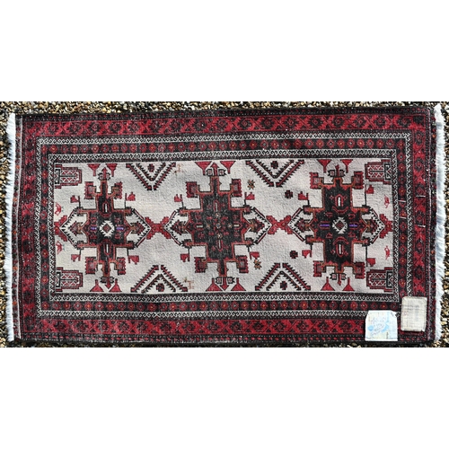 496 - A Persian Belouch rug, the geometric design on cream ground within repeating brown/red borders, fini... 