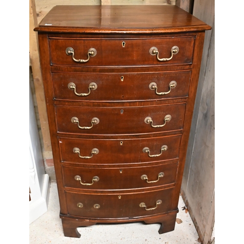 25 - A reproduction Georgian style mahogany six-drawer bow-fronted chest of drawers, raised on shaped bra... 