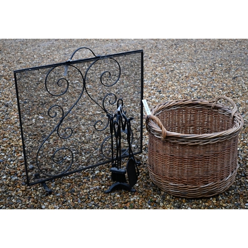 296 - A large circular wicker log basket to/with a spark guard and a fireside companion set (3)