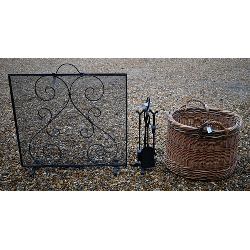 296 - A large circular wicker log basket to/with a spark guard and a fireside companion set (3)